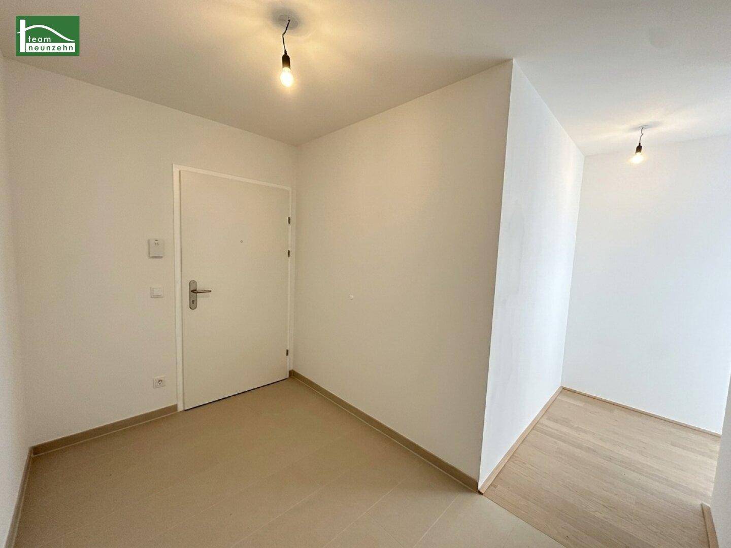 Eingangsbereich mit Fliesenboden und weißer Eingangstür.