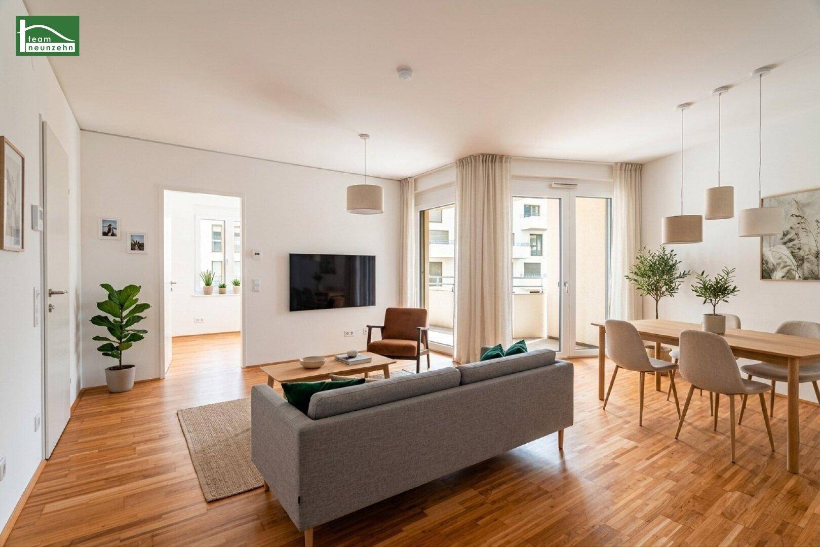 Heller, offener Wohn- und Essbereich mit Holzboden, Zugang zum Balkon und moderner Einrichtung.