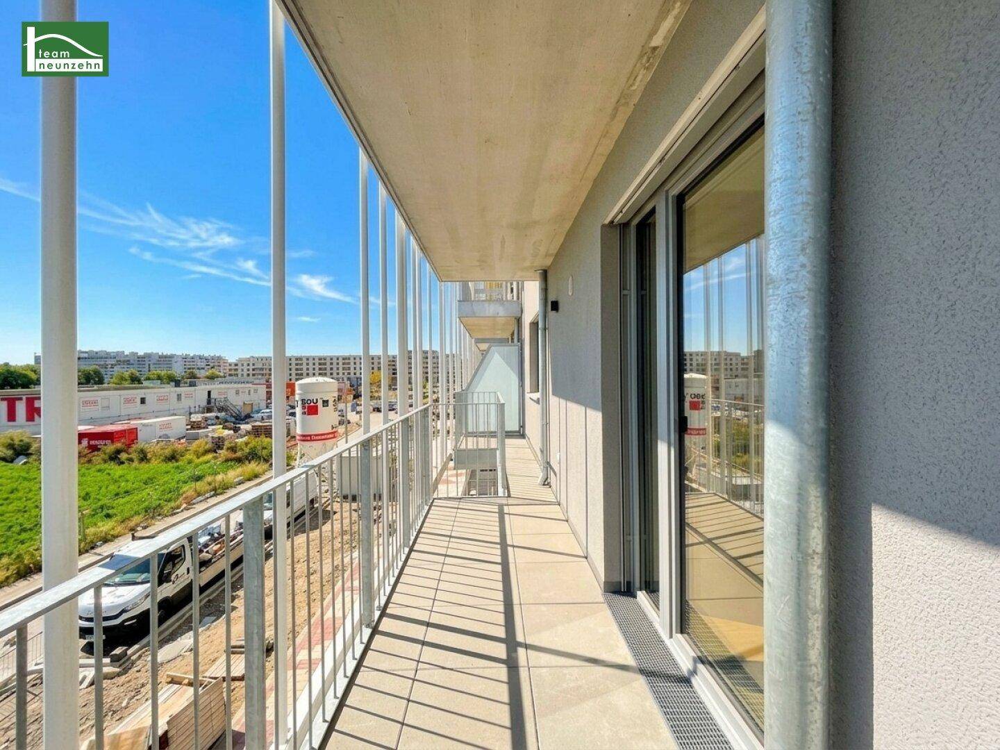 Langer Balkon mit Fliesenboden und moderner Brüstung, bietet einen weiten Blick auf die Umgebung.