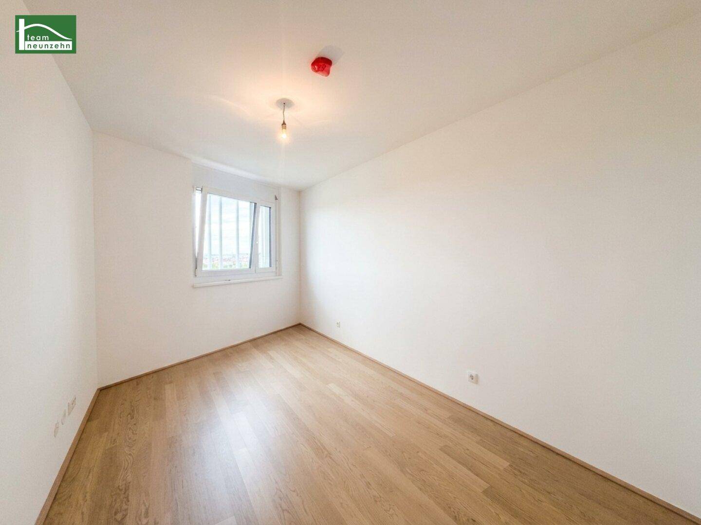 Ruhiges Schlafzimmer mit hellem Holzboden und einem Fenster, ideal für erholsame Nächte.