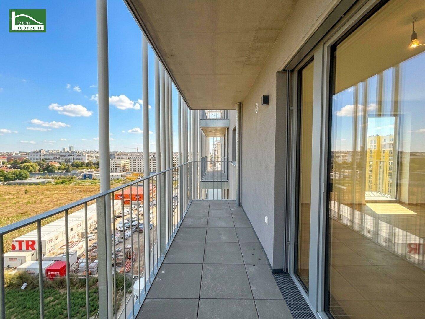 Langer Balkon mit Fliesenboden und Metallgeländer, bietet einen weiten Blick über die Umgebung.