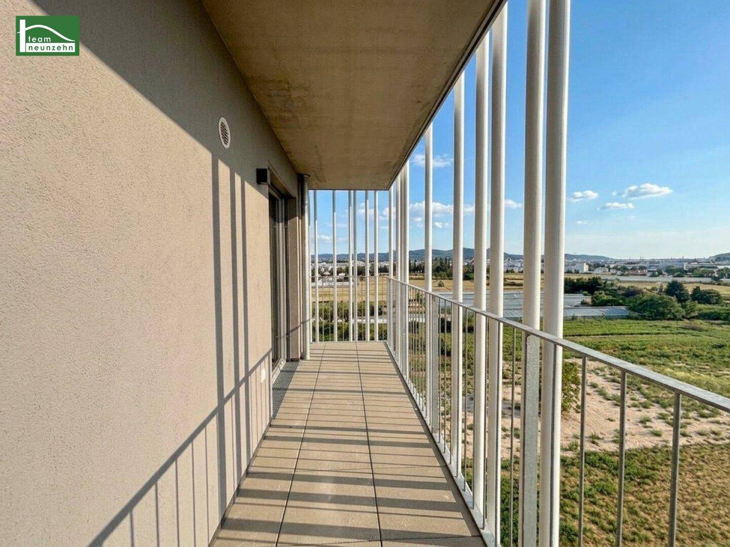 Geräumiger Balkon mit moderner Architektur und weitem Blick über die grüne Landschaft.