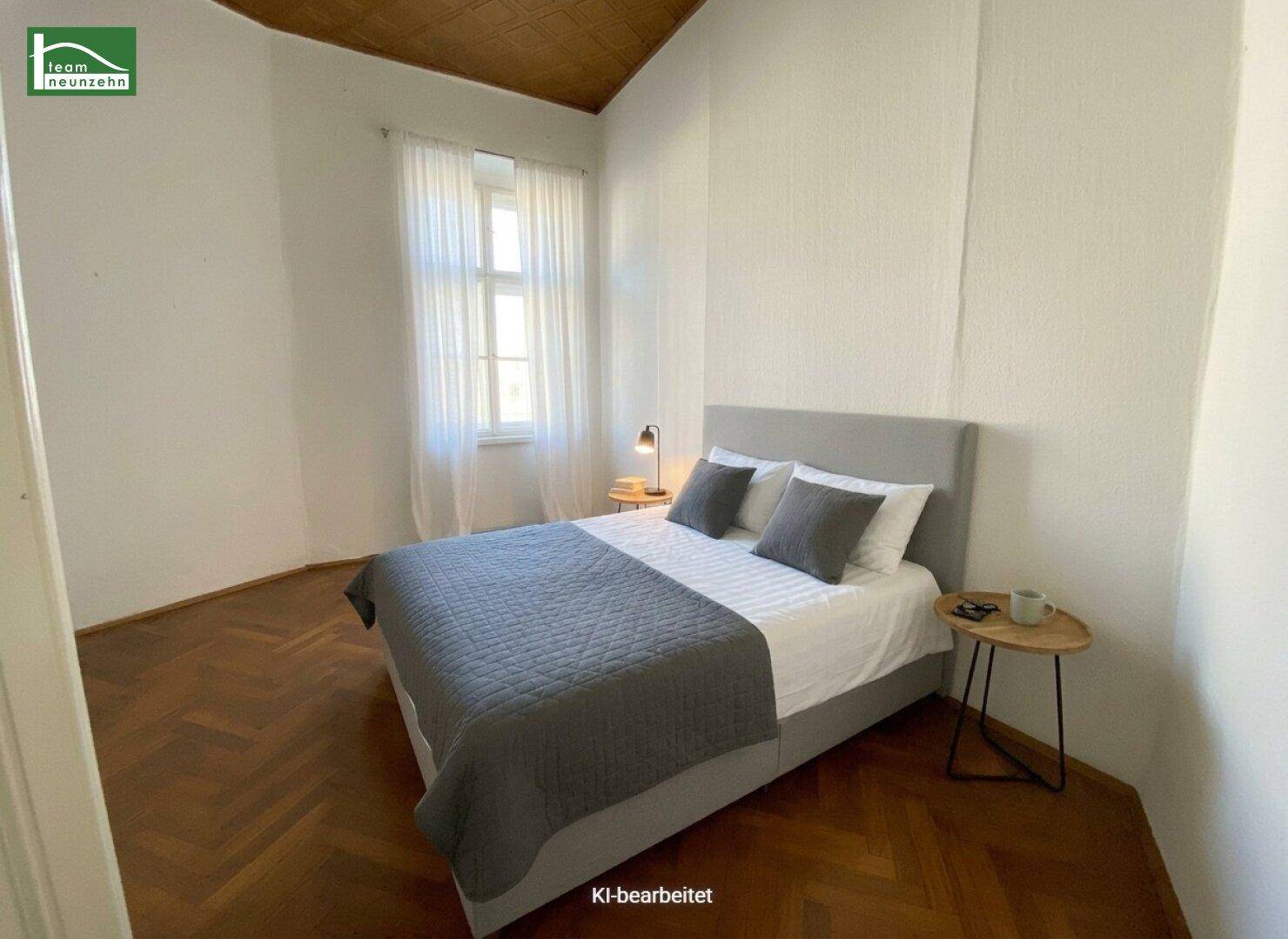 Helles Schlafzimmer mit Doppelbett, Holzboden und einem großen Fenster für viel Tageslicht.