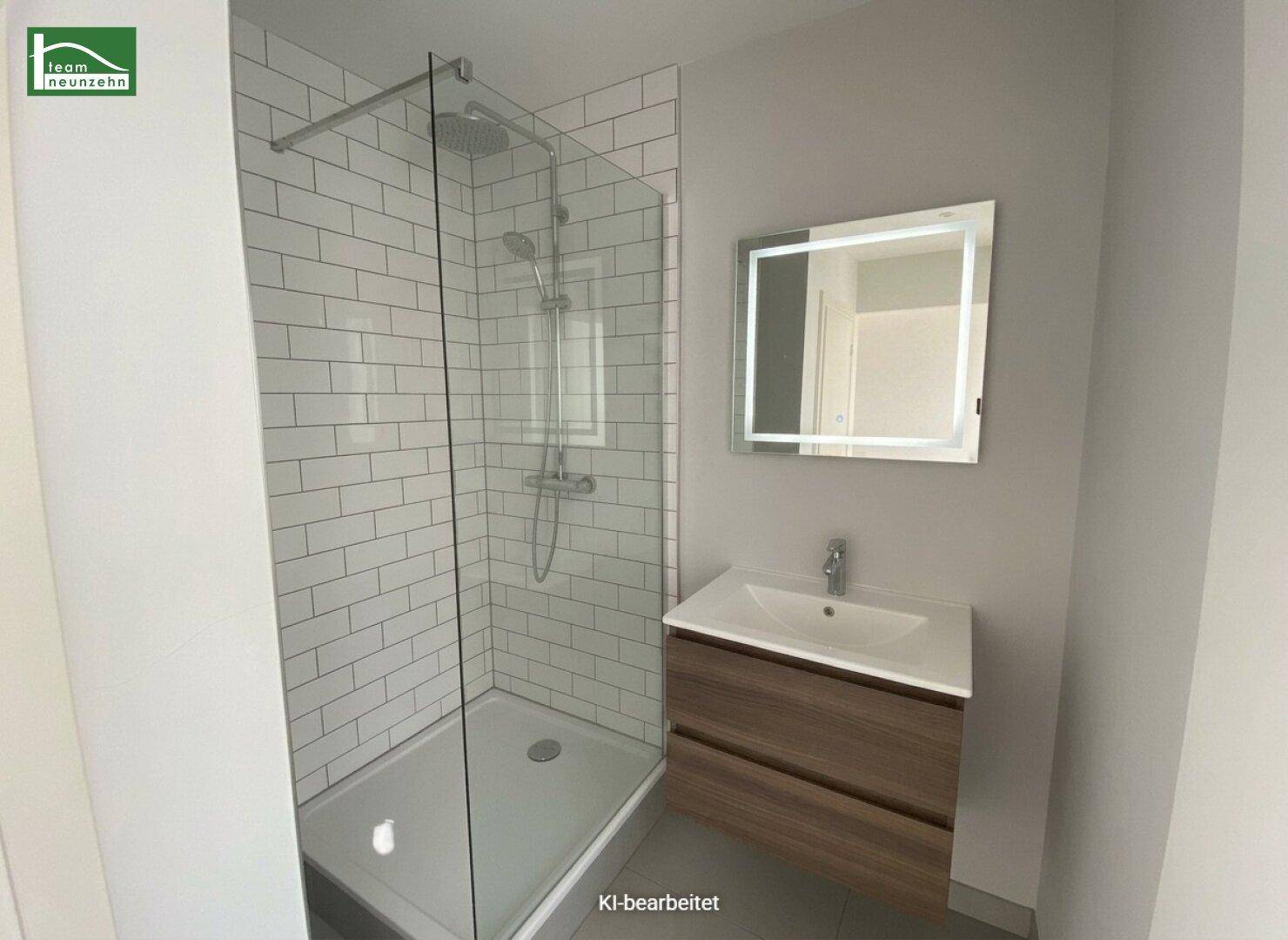 Modernes Badezimmer mit begehbarer Dusche, weißen Fliesen und beleuchtetem Spiegel.