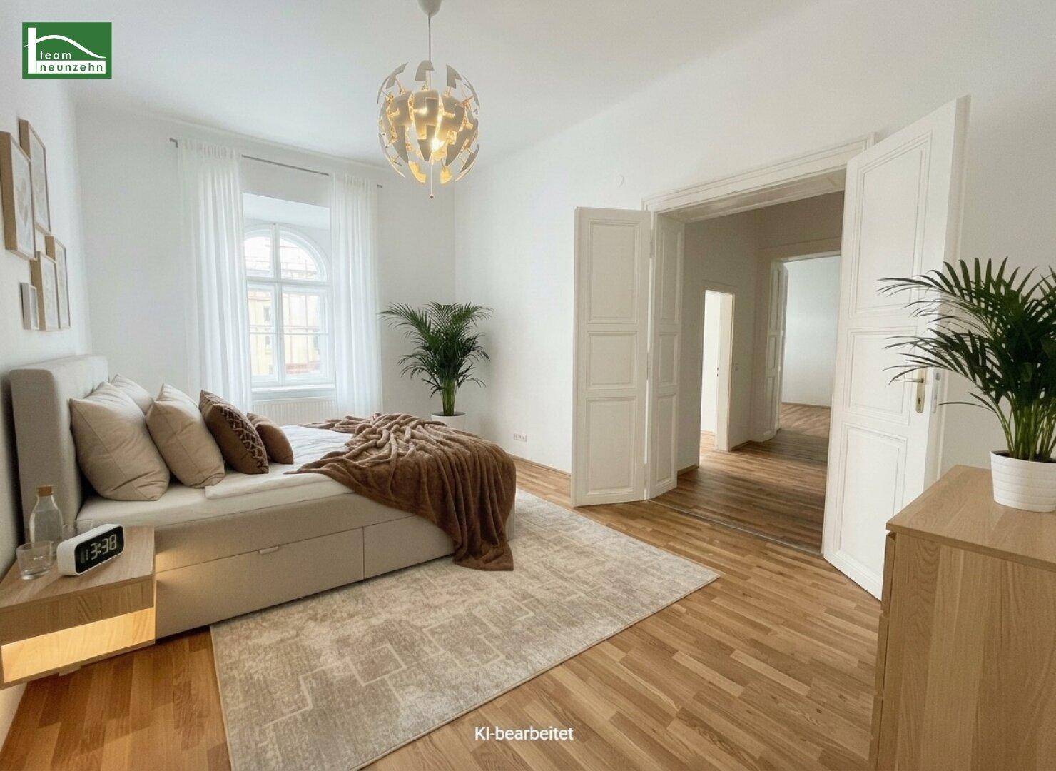 Helles Schlafzimmer mit Holzboden, großem Bett und Blick durch ein Rundbogenfenster.
