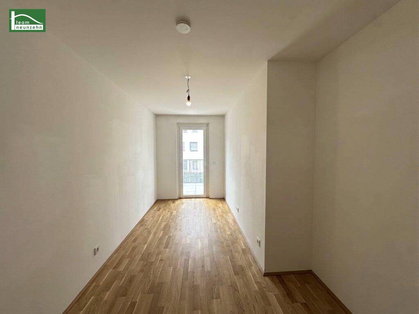 Helles Schlafzimmer mit Parkettboden und Zugang zu einem kleinen französischen Balkon.