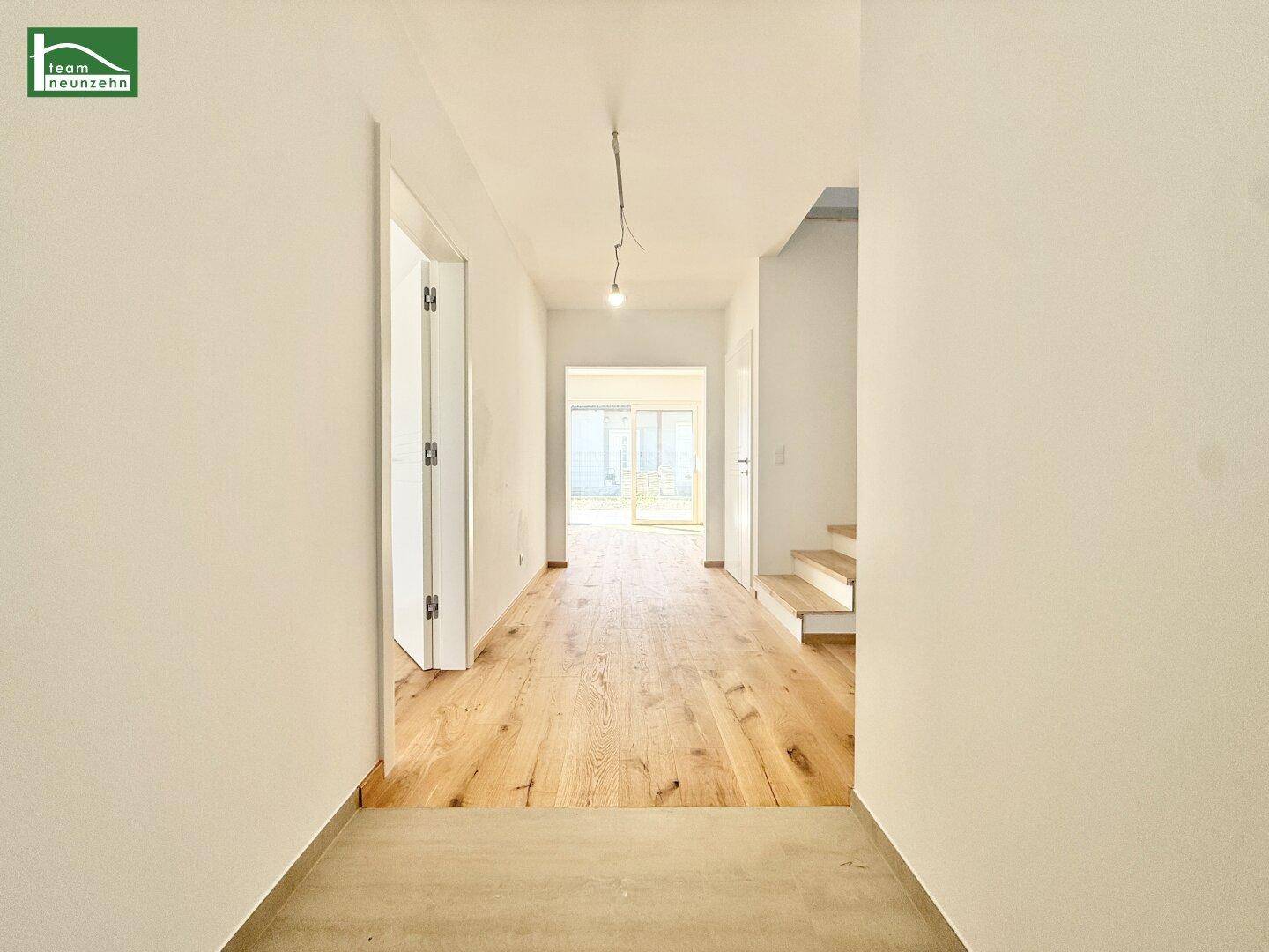 Heller Flur mit Echtholzparkett und Treppenaufgang, der zu weiteren Räumen führt.