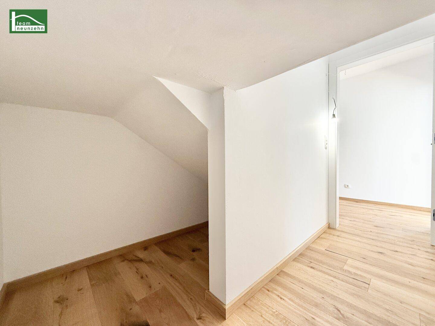 Innenraum mit Dachschräge und Holzboden, möglicherweise ein Abstellraum oder Dachboden.
