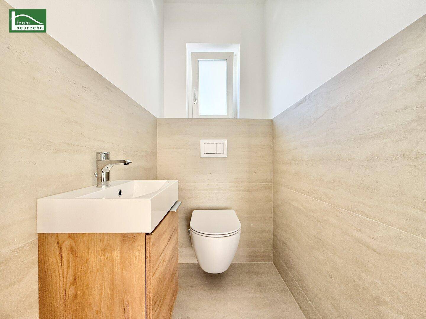 Modernes Gäste-WC mit wandhängendem WC, Waschbecken und schmalem Fenster.