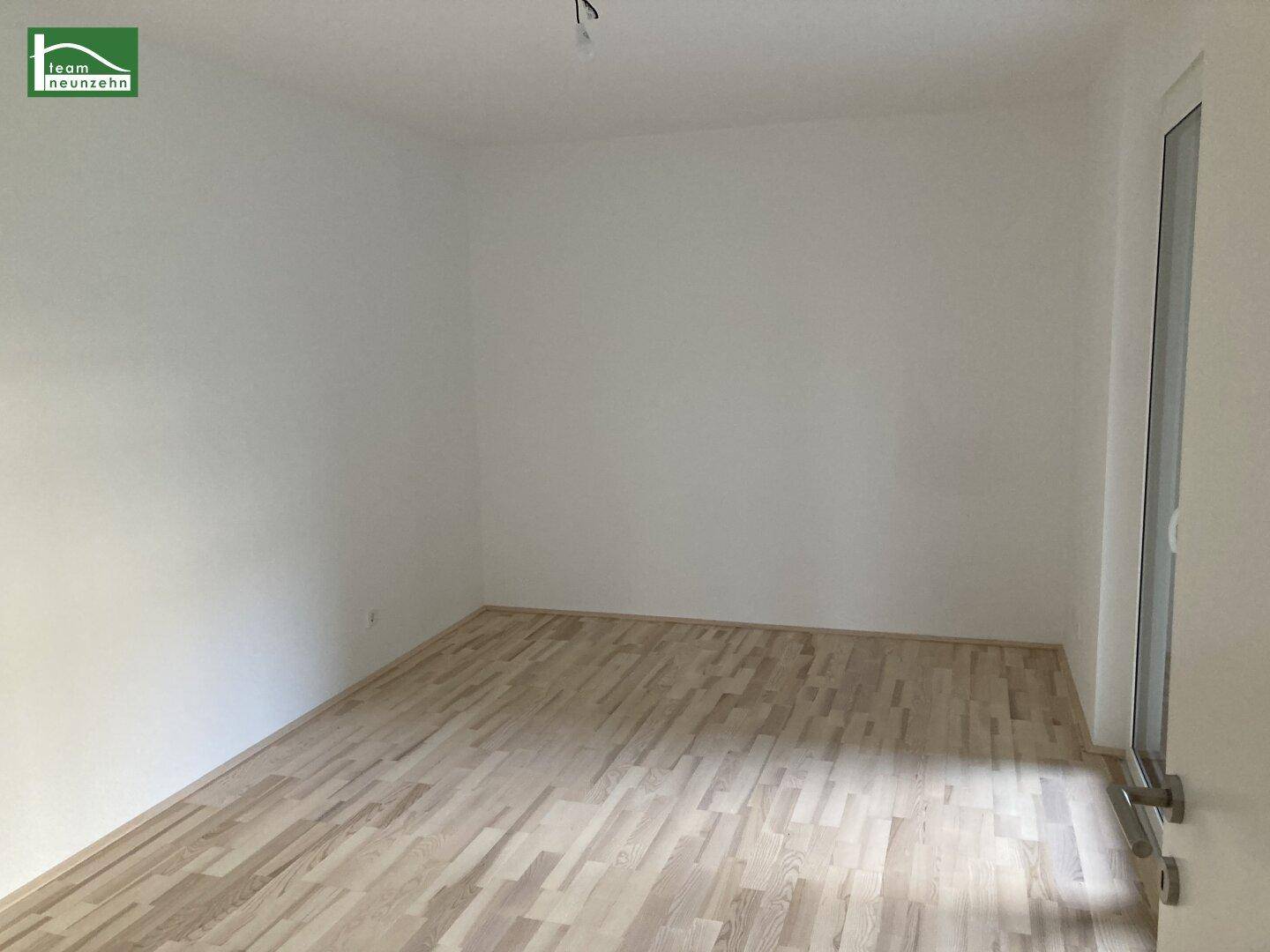 Leeres Schlafzimmer mit hellem Parkettboden und Fenster, bereit zur individuellen Gestaltung.