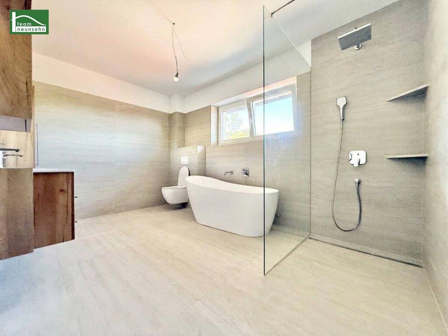 Geräumiges Badezimmer mit großer begehbarer Dusche, freistehender Wanne und modernem Design.