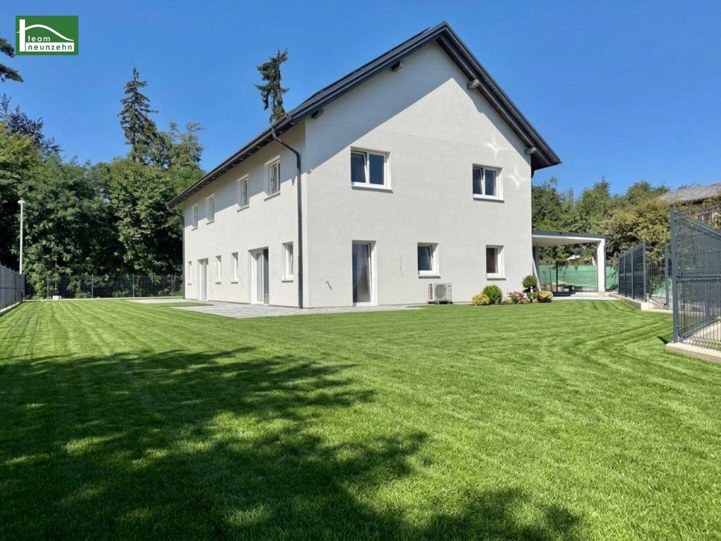 Großer, gepflegter Garten mit Rasenfläche und Blick auf das moderne Einfamilienhaus.