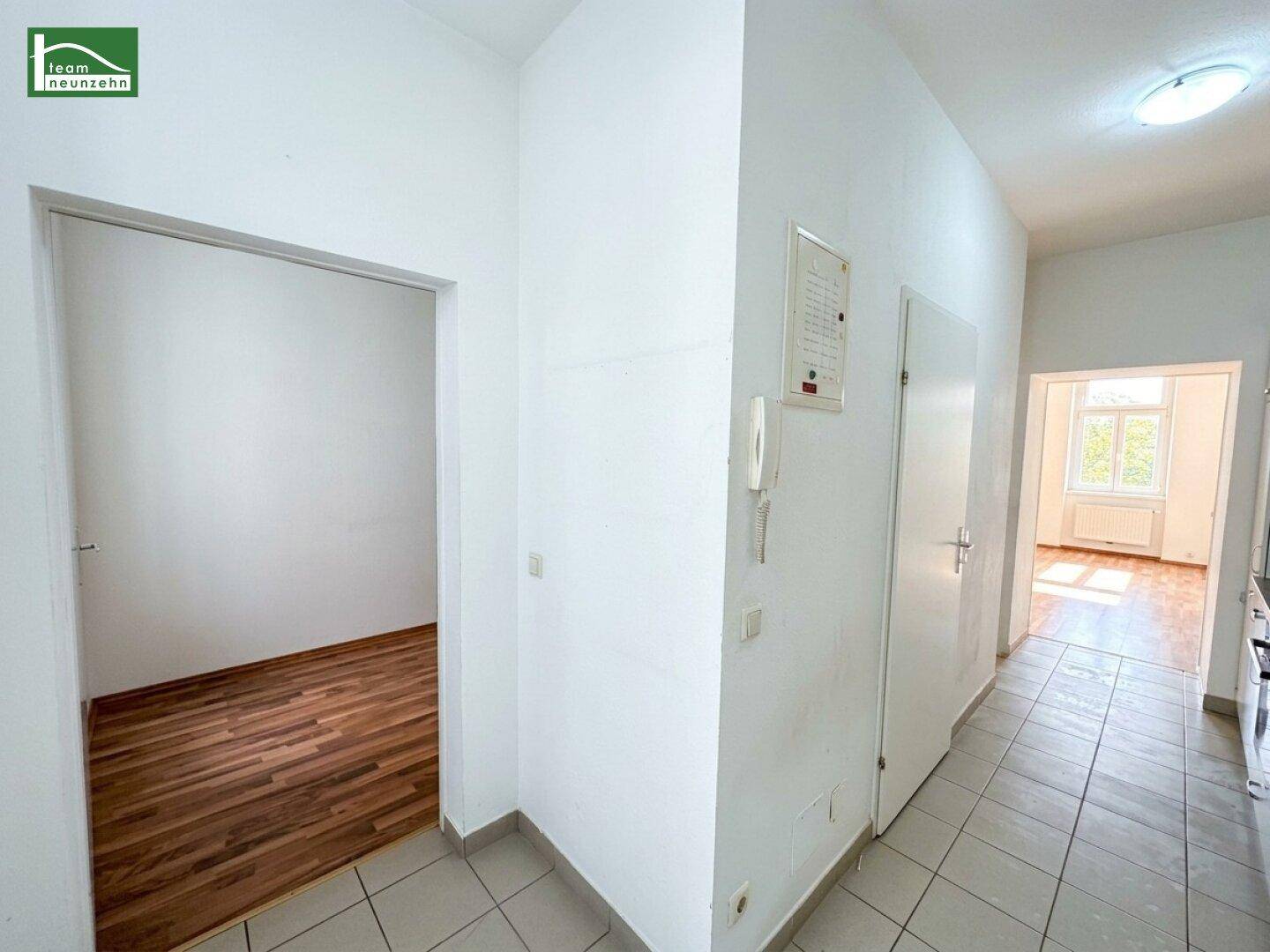 Heller Flur mit Fliesenboden und Zugang zu verschiedenen Zimmern der Wohnung.