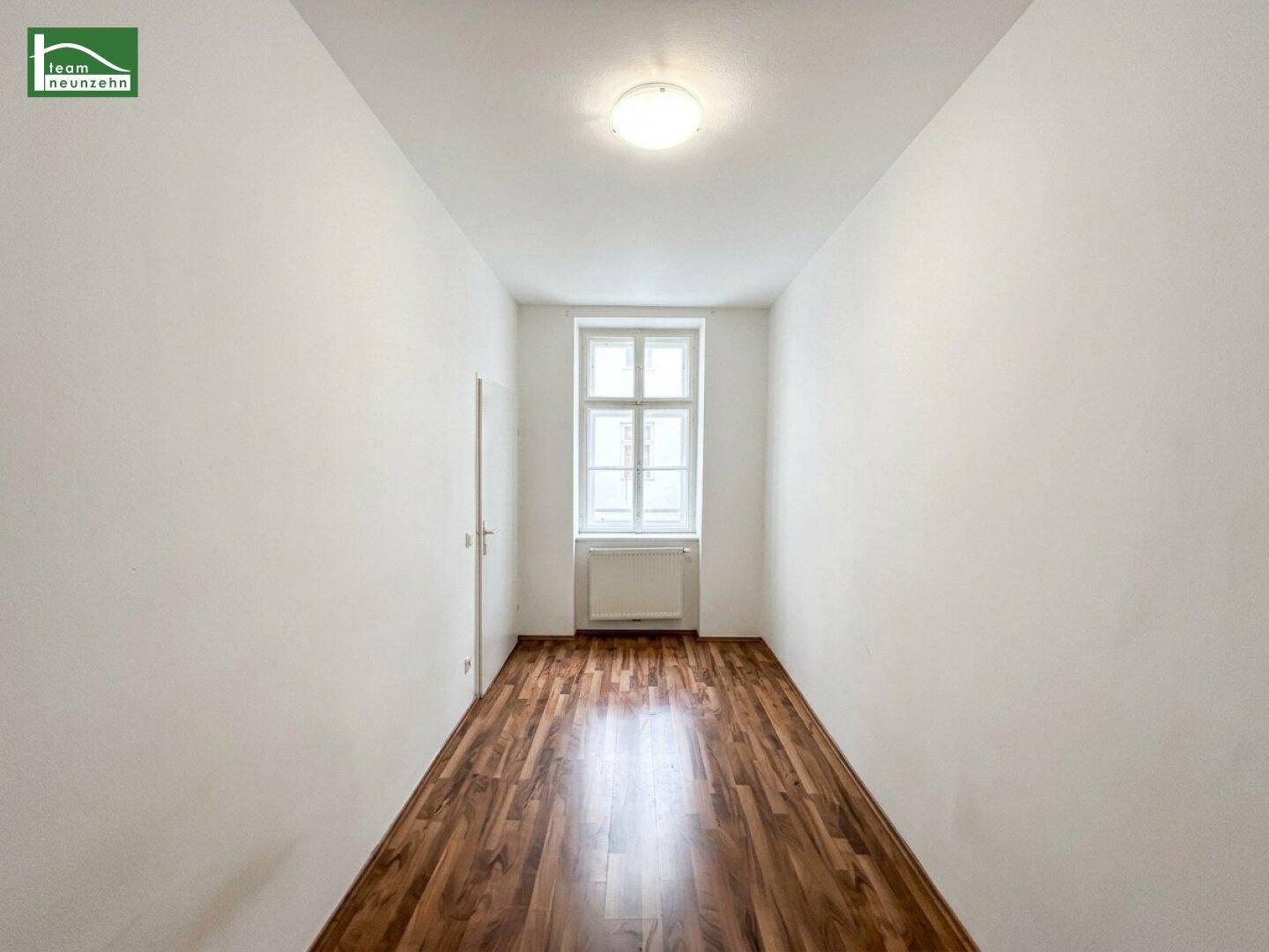 Ruhiges Zimmer mit einem Fenster, Holzboden und ausreichend Platz für Möbel.