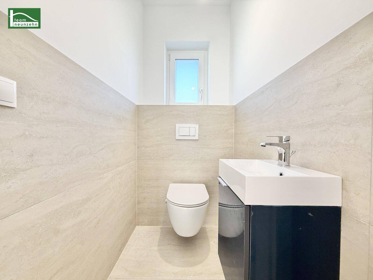 Modernes Gäste-WC mit Wand-WC, kleinem Waschbecken und Fenster.