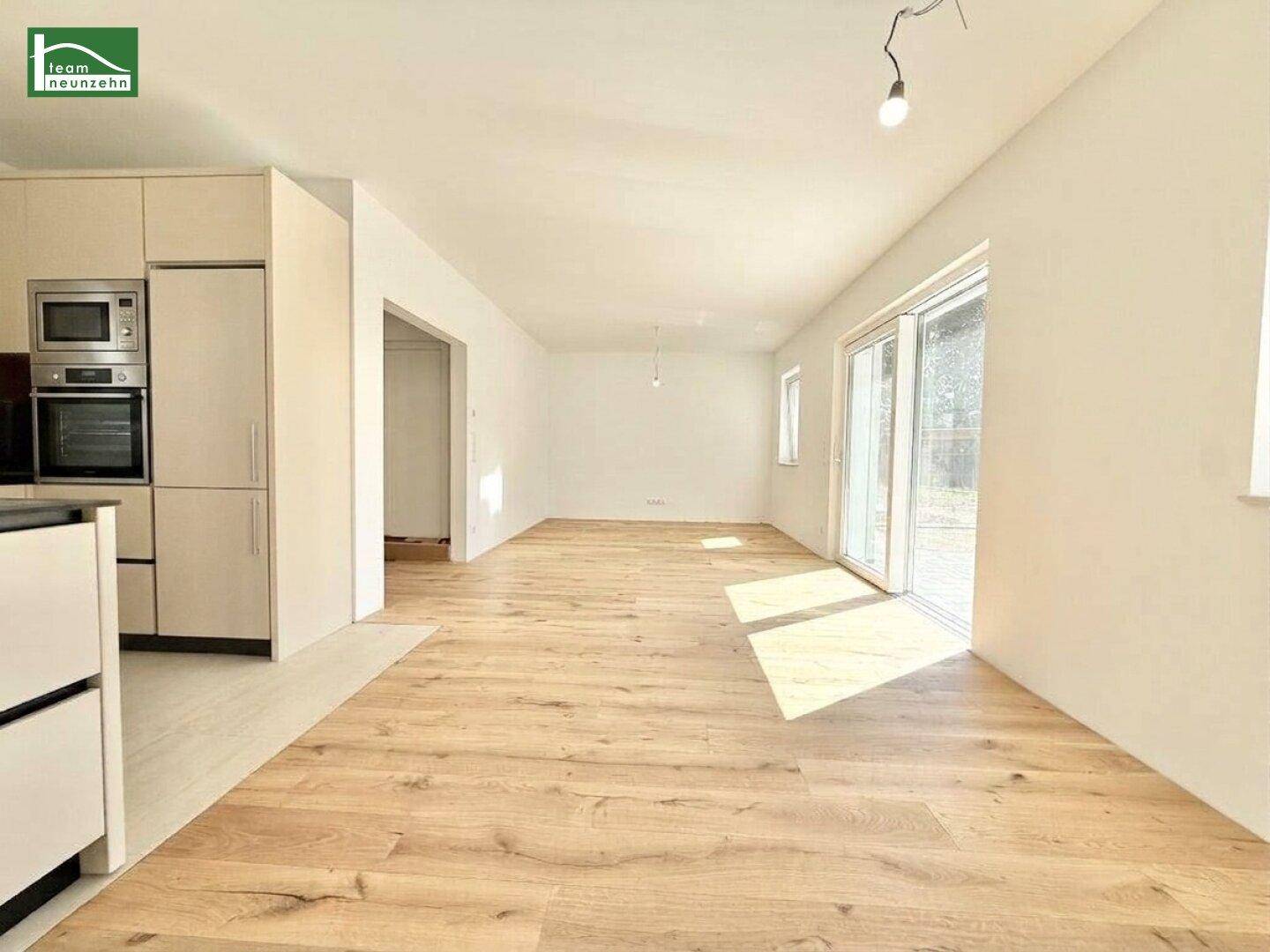 Heller, offener Wohnbereich mit großen Schiebetüren und hochwertigem Holzboden.