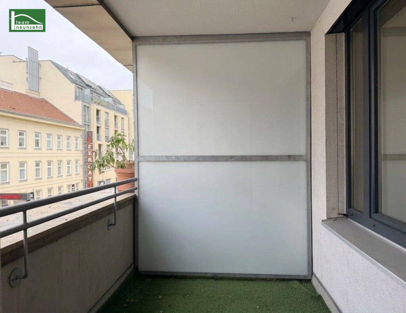 Balkon mit Kunstrasen und Milchglas-Brüstung, bietet einen privaten Außenbereich.