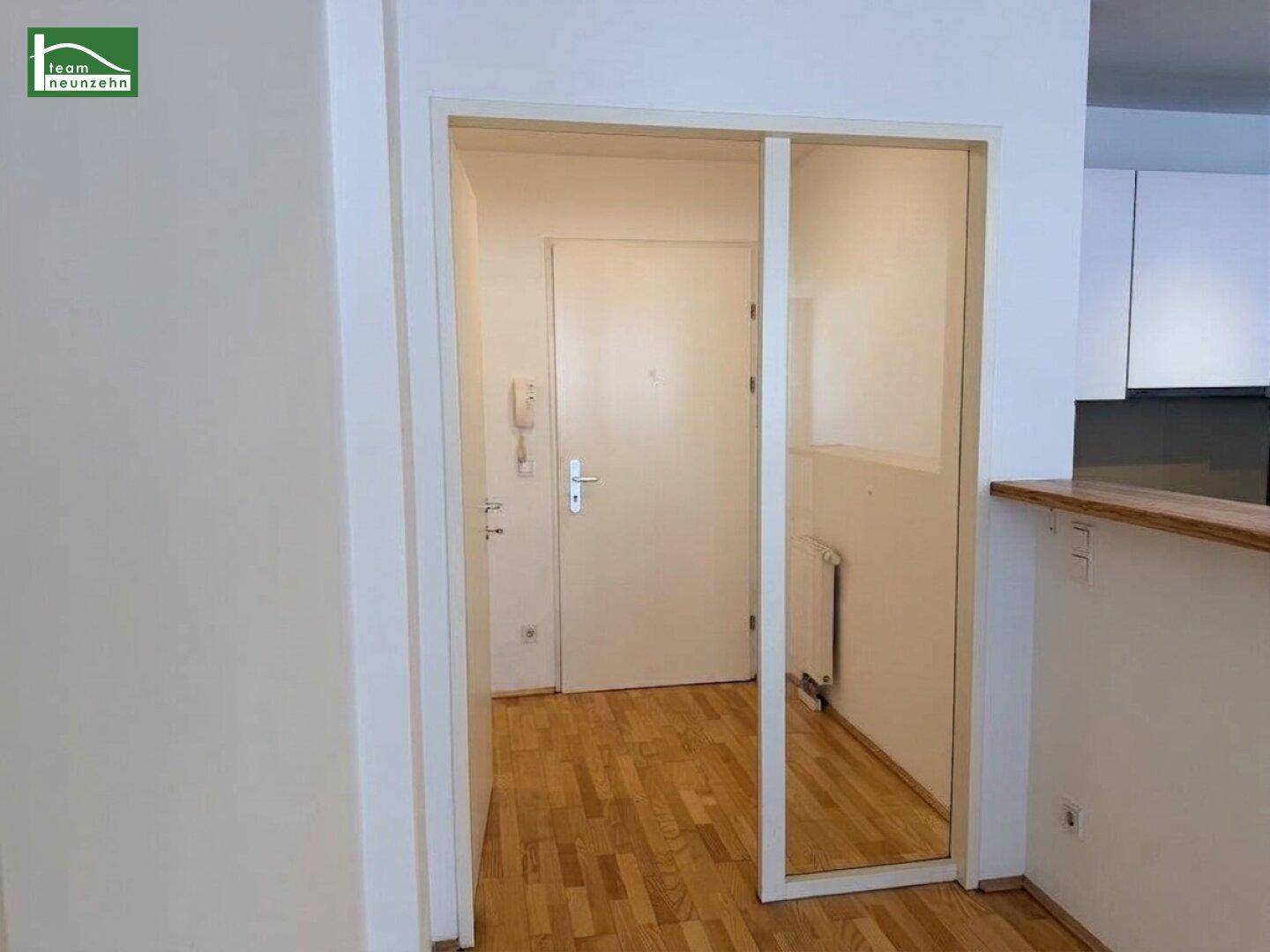 Blick vom Wohnbereich in den Flur mit Eingangstür und Gegensprechanlage.