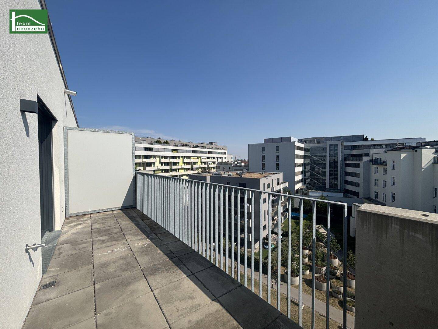 Geräumiger Balkon mit Fliesenboden und Metallgeländer, bietet einen weiten Stadtblick.