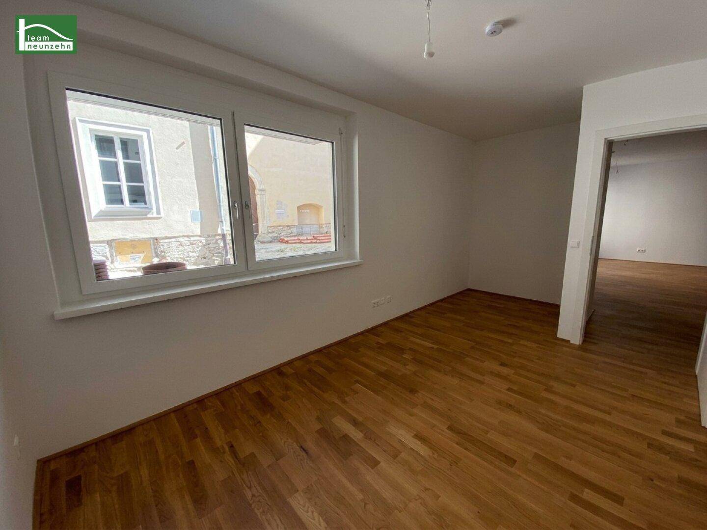 Leerer Raum mit Parkettboden und Fenster, ideal als Schlafzimmer oder Arbeitszimmer nutzbar.