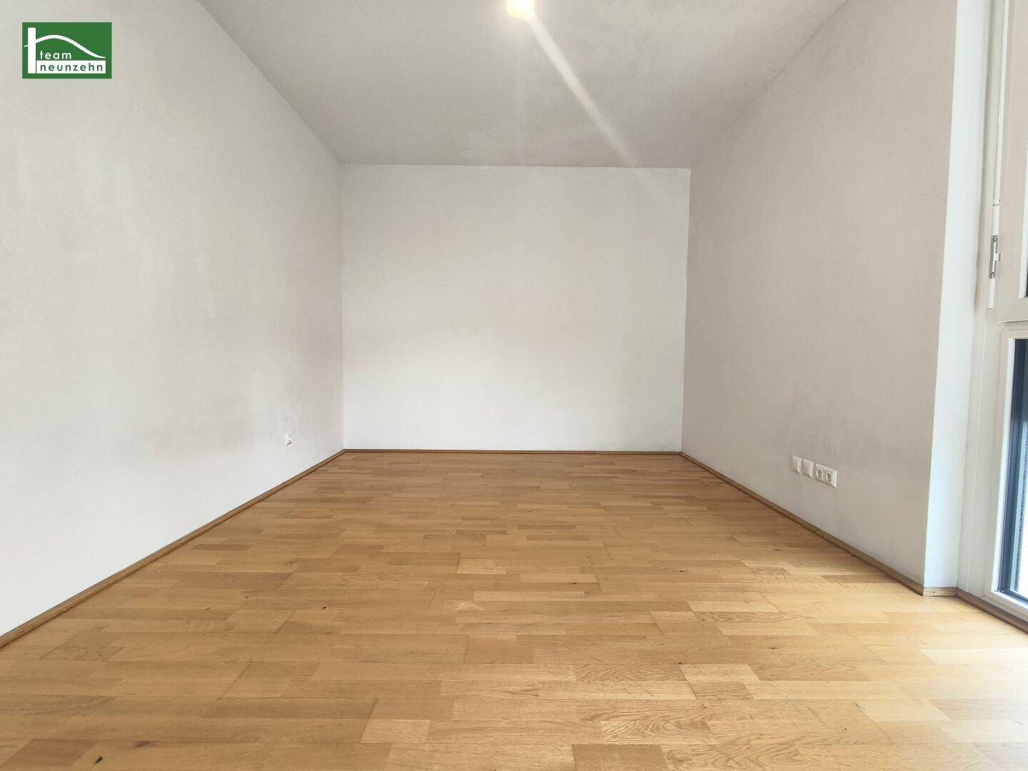 Helles Zimmer mit Parkettboden und weißen Wänden, ideal als Schlaf- oder Arbeitszimmer.