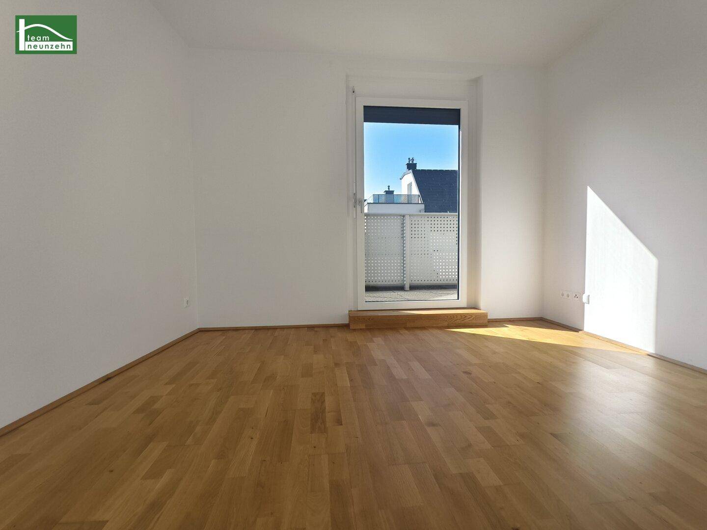 Helles Zimmer mit Parkettboden und direktem Zugang zu einem Balkon, ideal als Schlafzimmer.