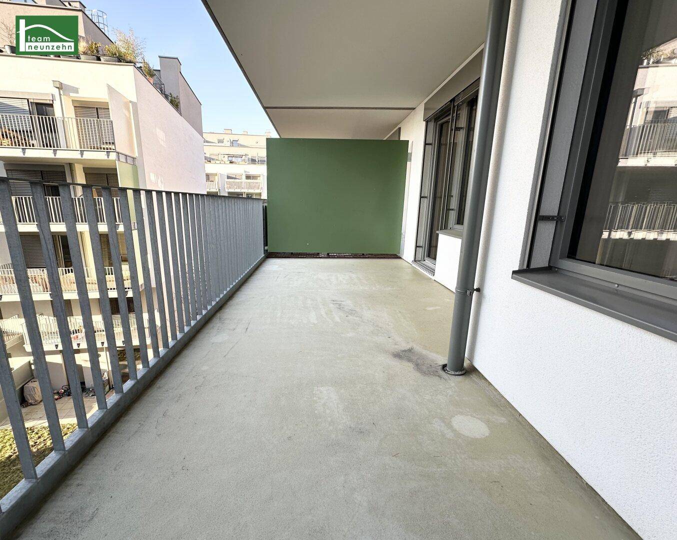 Geräumiger Balkon mit Betonboden und Metallgeländer, ideal für Entspannung im Freien.