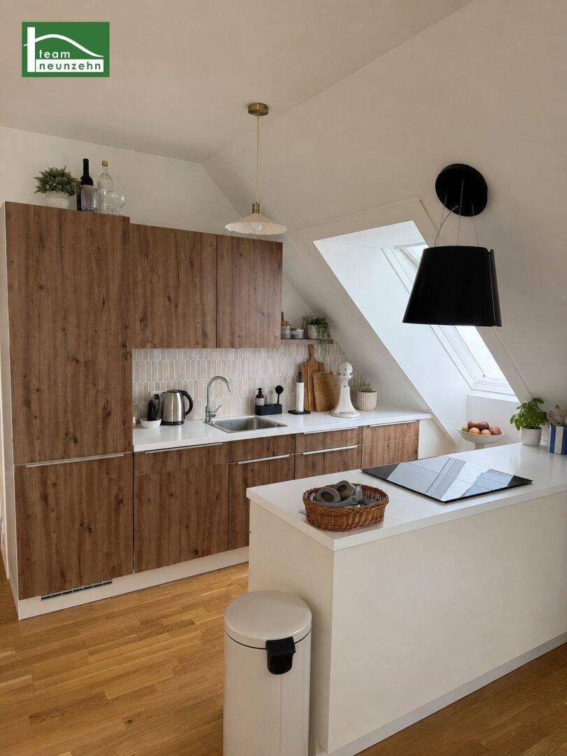 Moderne Küche im Dachgeschoss mit Holzfronten, Kochinsel, Induktionskochfeld und Dachfenster.
