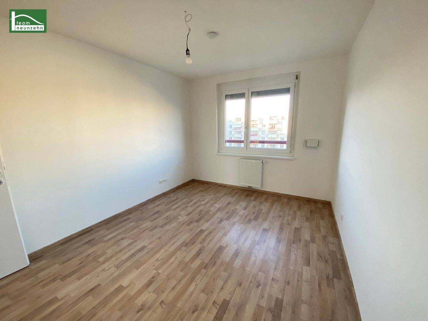 Helles, unmöbliertes Zimmer mit Parkettboden und Fenster, ideal als Schlaf- oder Gästezimmer.