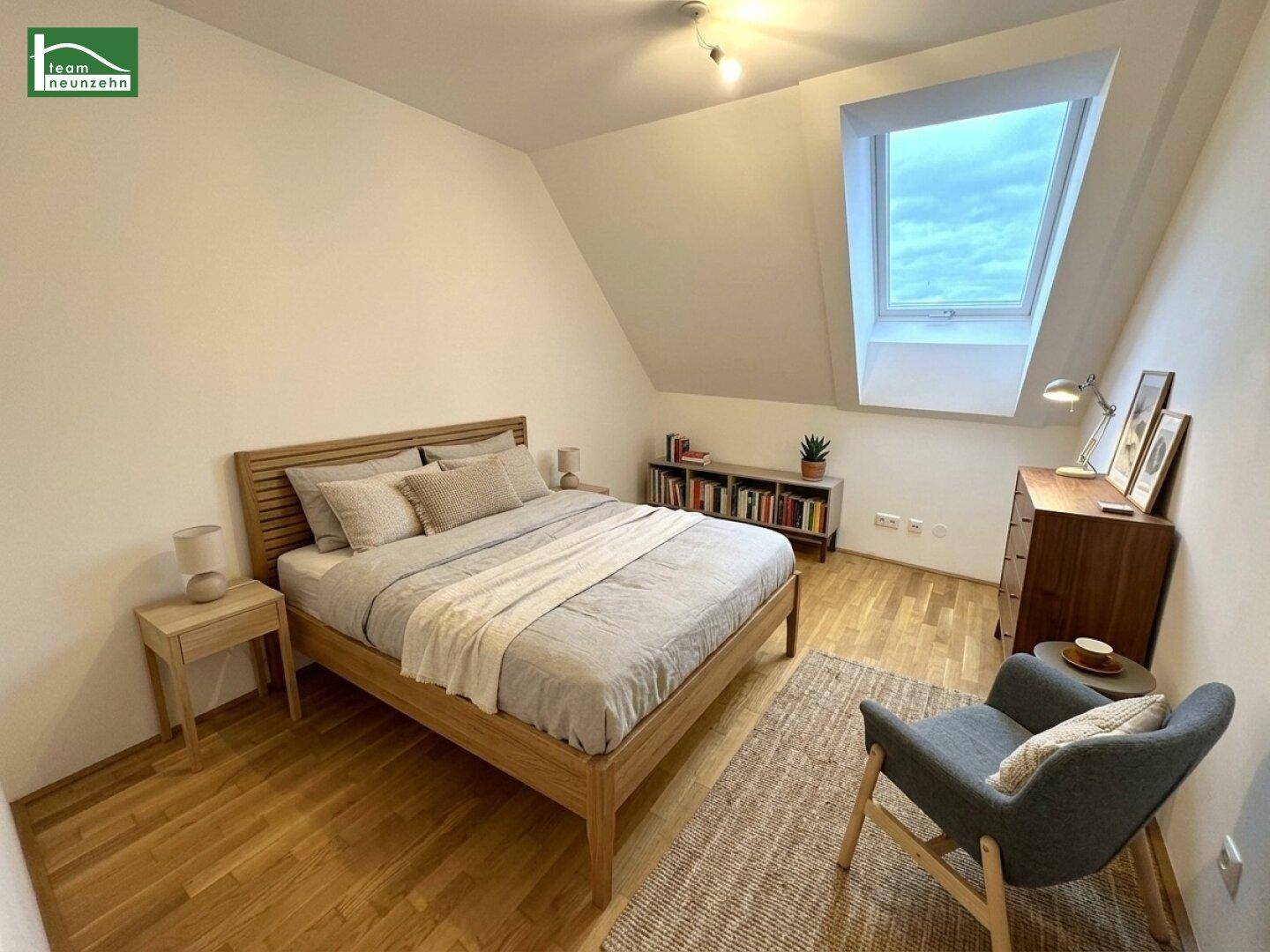 Gemütliches Schlafzimmer mit Holzbett, Parkettboden und einem großen Dachfenster.