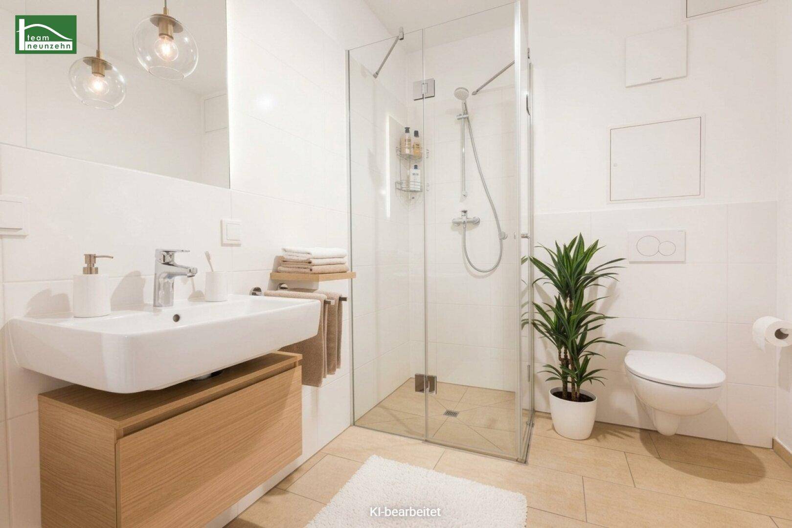 Helles modernes Badezimmer mit ebenerdiger Dusche, Waschbecken und WC.