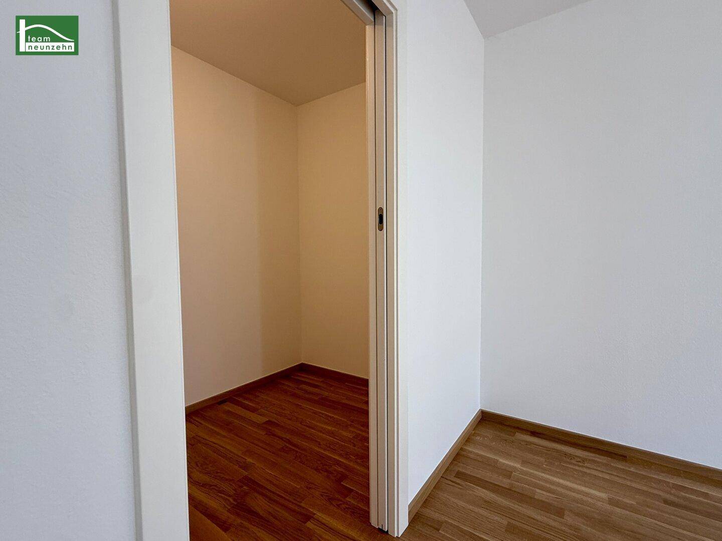 Kleiner Abstellraum mit Holzparkettboden und einer Schiebetür, ideal für zusätzlichen Stauraum oder als begehbarer Schrank.