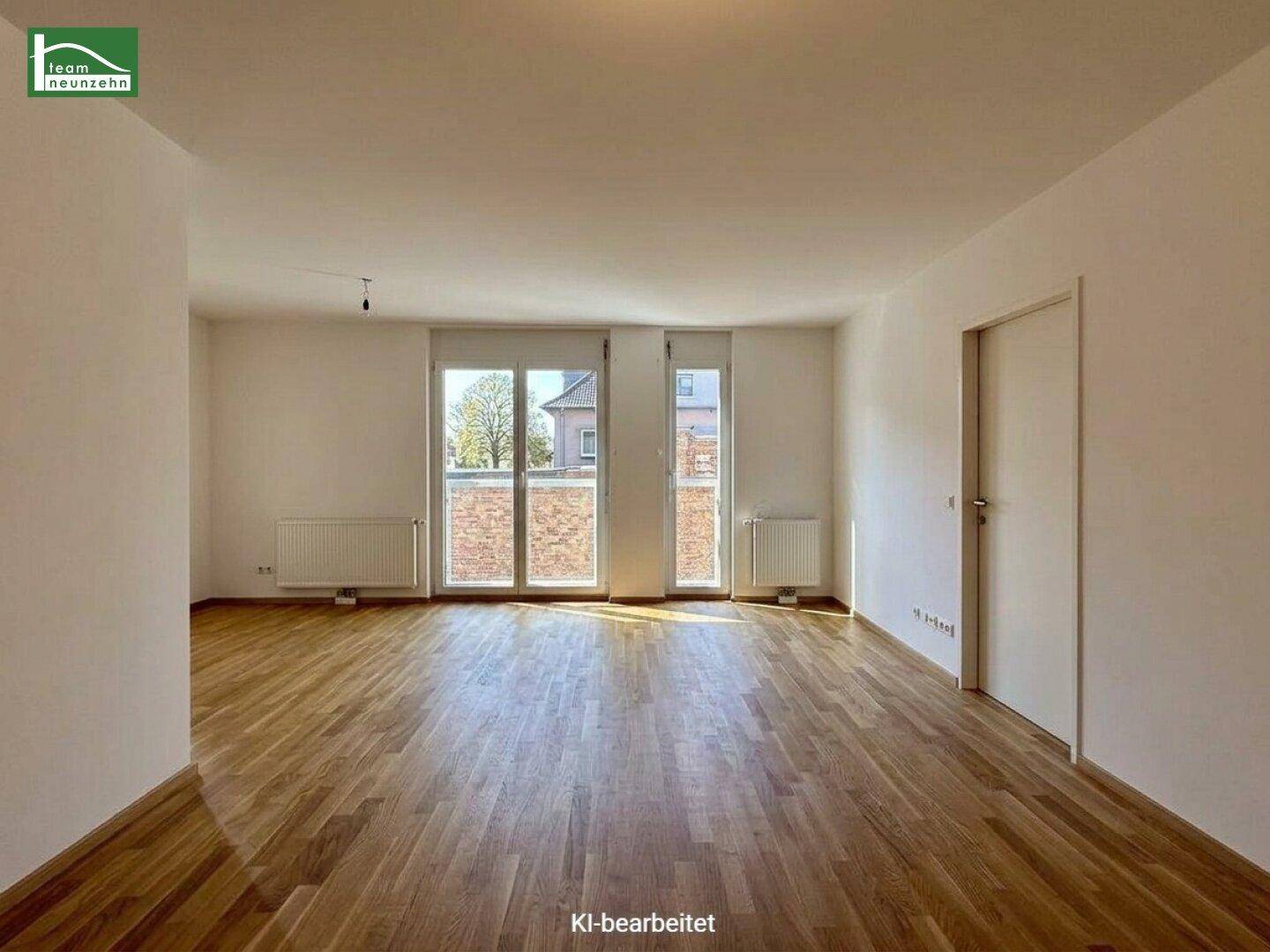 Heller Wohnbereich mit Holzparkettboden und großen Fenstertüren, die viel Tageslicht hereinlassen und Zugang bieten.