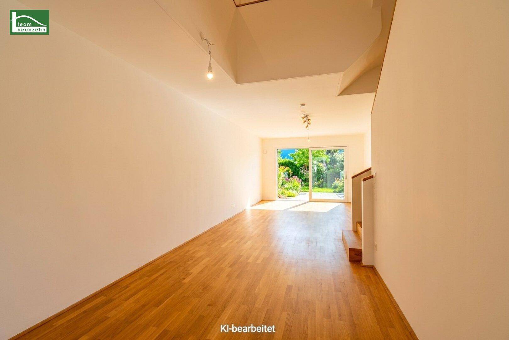 Geräumiges Wohnzimmer mit Holzboden, viel Tageslicht und Zugang zum Garten.