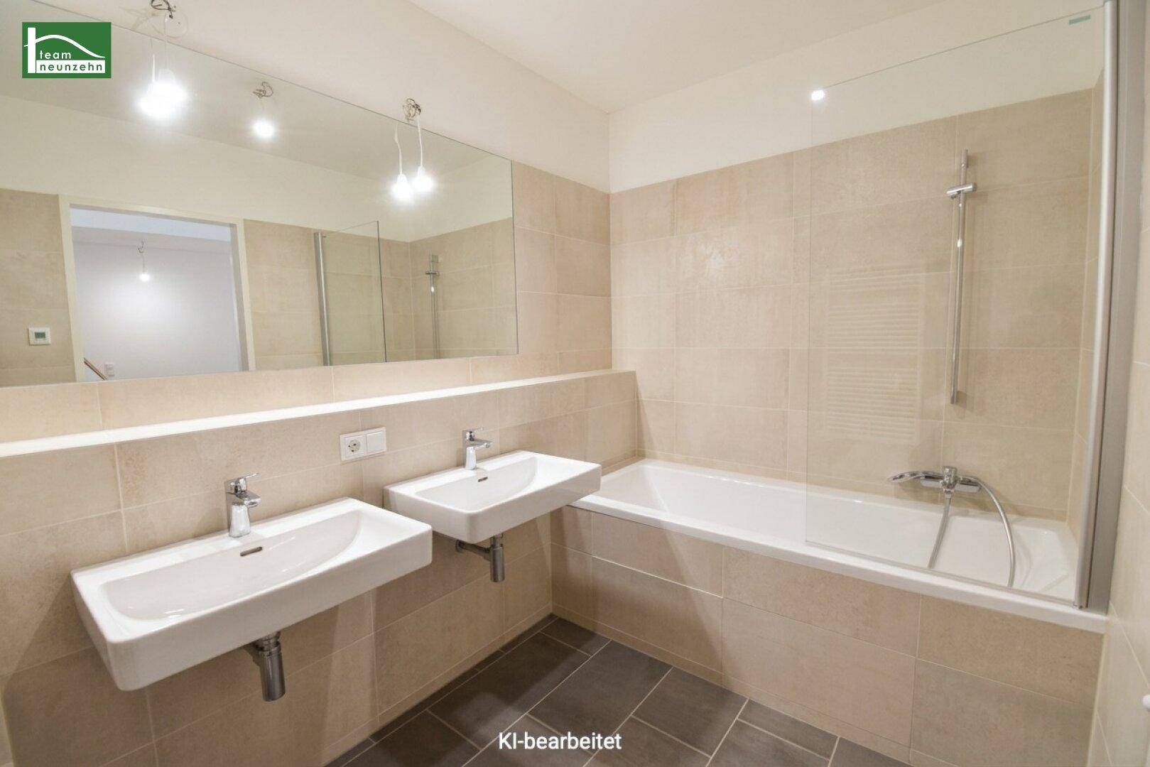 Modernes Badezimmer mit Doppelwaschbecken, Badewanne und beigefarbenen Wandfliesen.