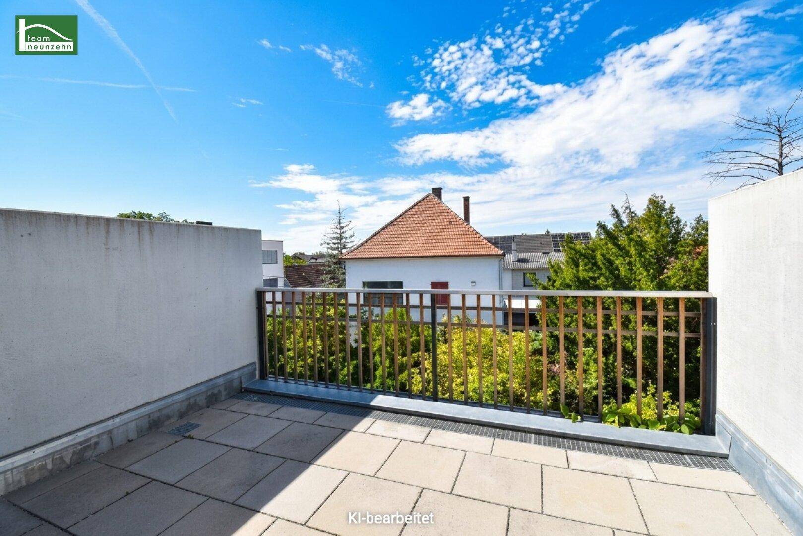 Helle Dachterrasse mit Fliesenboden und Blick auf die umliegenden Häuser und Bäume.