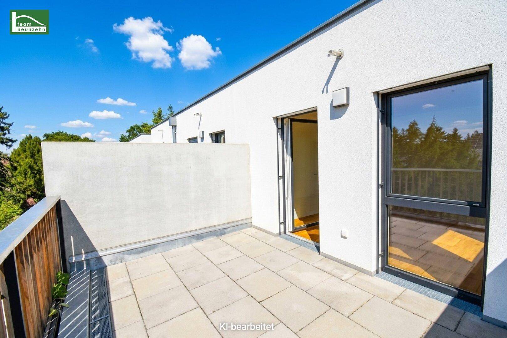 Geräumige Terrasse mit Fliesenboden und Zugang zu den Innenräumen des modernen Gebäudes.