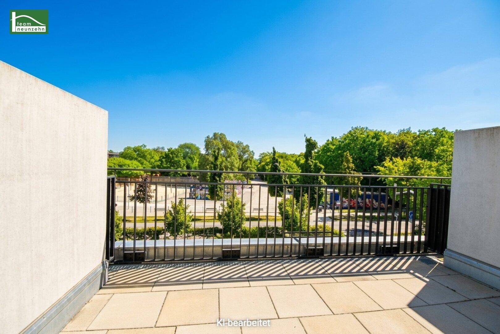 Sonniger Terrassenbereich mit Fliesenboden und weitem Blick auf Grünflächen und die Umgebung.