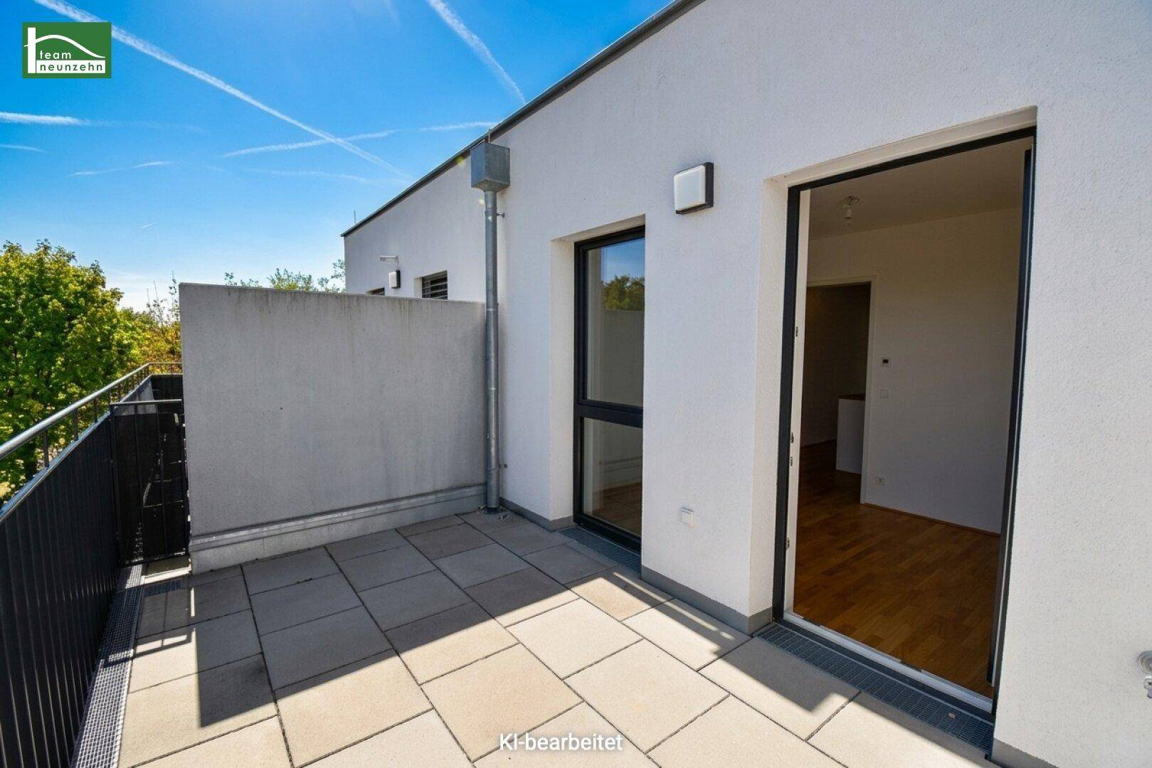 Moderne Terrasse mit Fliesenboden und direktem Zugang zu den hellen Innenräumen des Hauses.