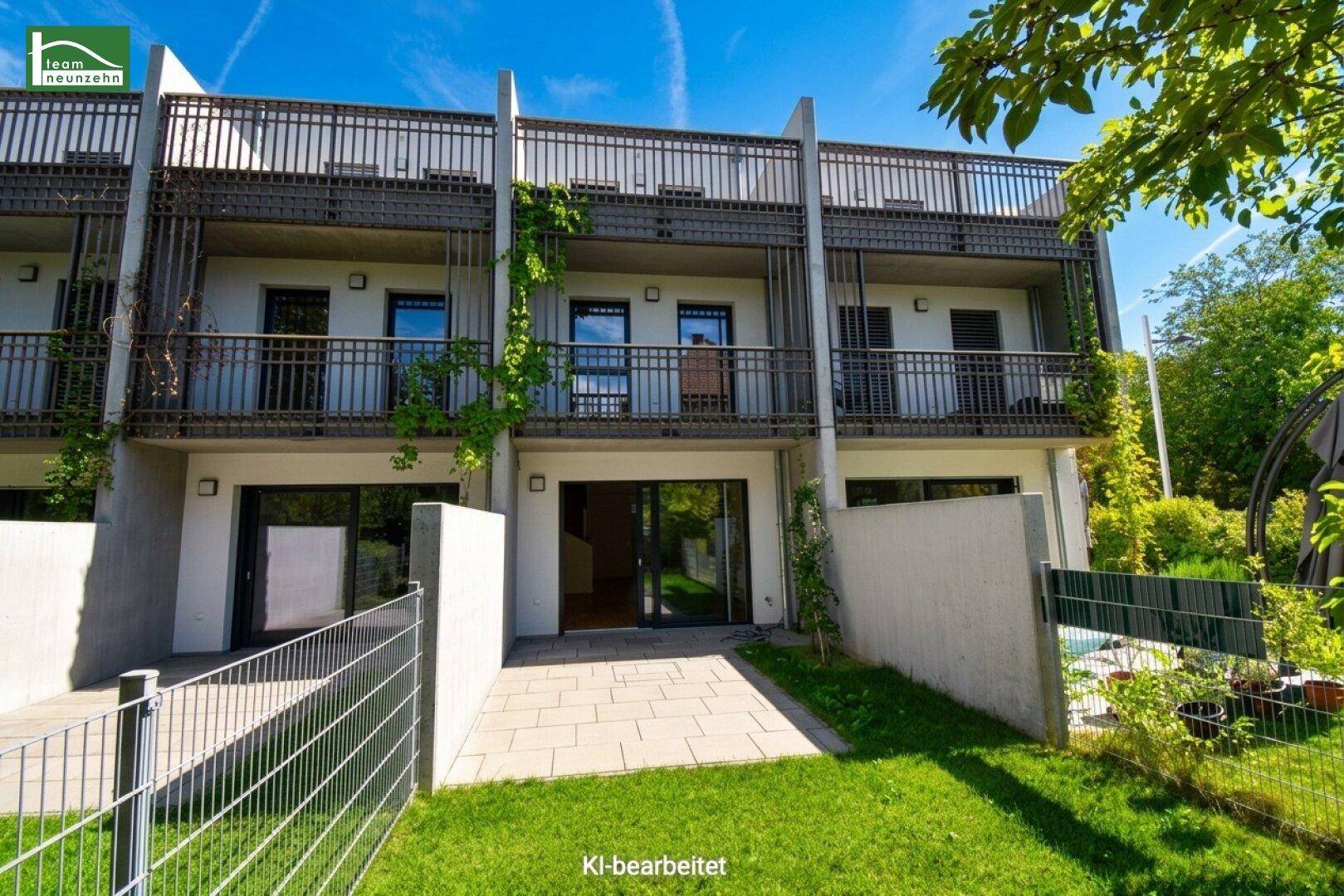 Moderne Reihenhäuser mit Balkonen und Terrassen, umgeben von grünen Gärten.