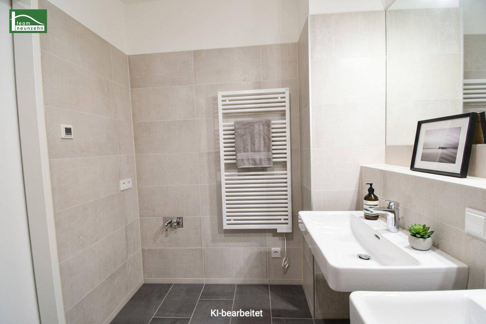 Modernes Badezimmer mit Einzelwaschbecken, beheiztem Handtuchhalter und großen Fliesen.
