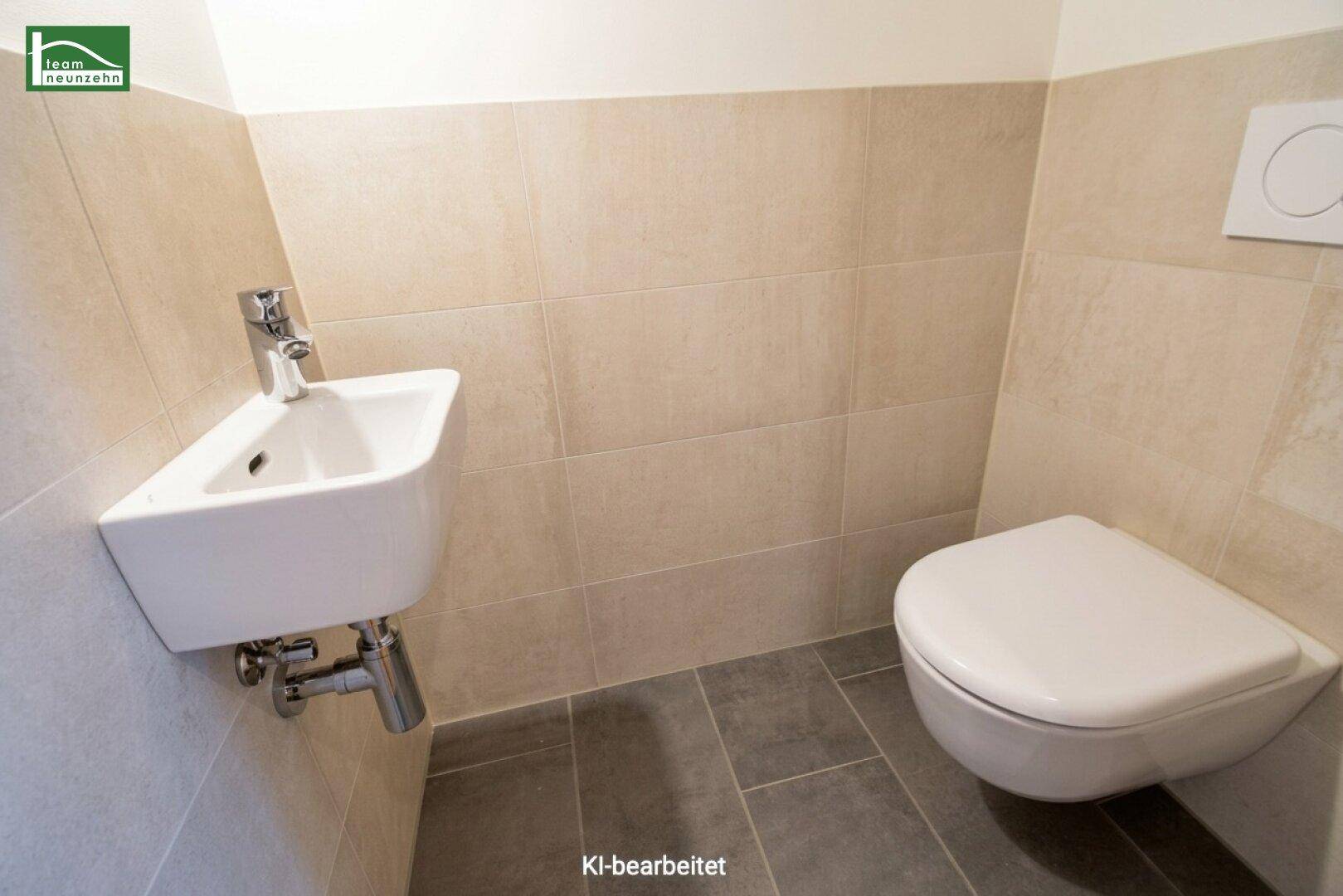 Modernes Gäste-WC mit Wand-WC und kleinem Waschbecken, ausgestattet mit beigen und grauen Fliesen.