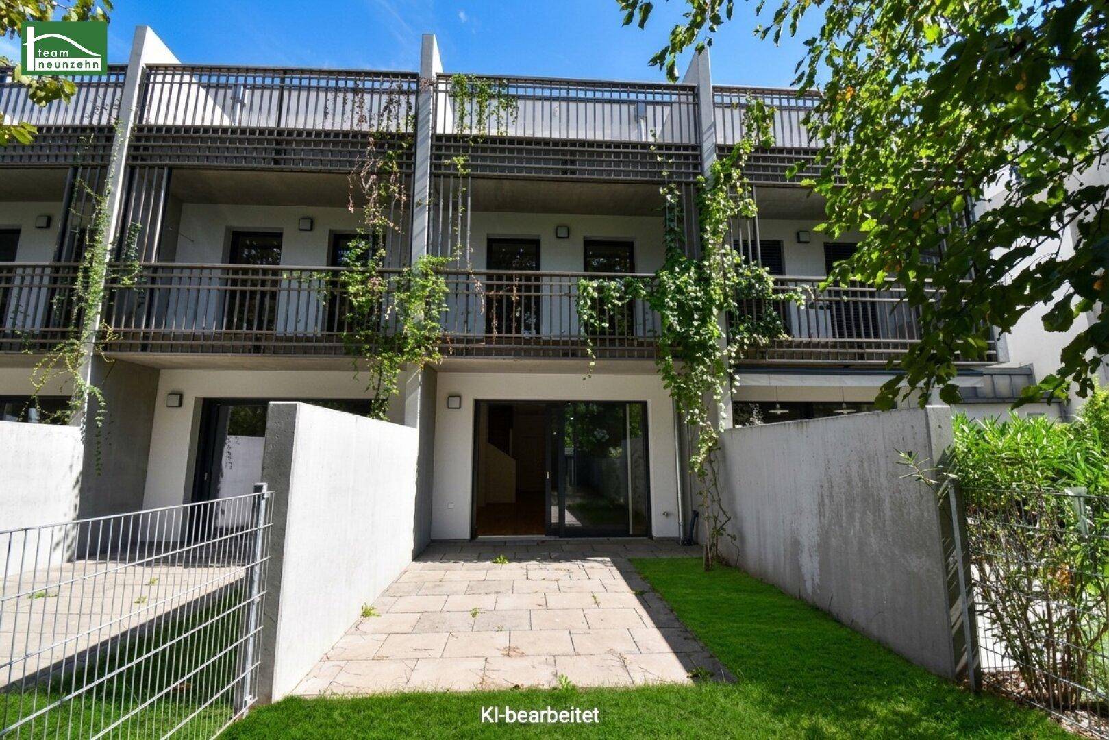 Moderne Reihenhausfassade mit mehreren Balkonen und begrüntem Gartenbereich im Vordergrund.
