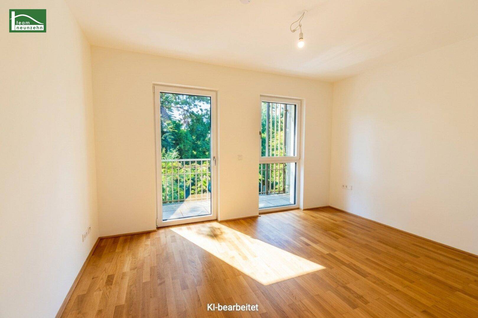 Geräumiges Zimmer mit Holzboden und Balkonzugang, ideal als Schlafzimmer mit viel natürlichem Licht.