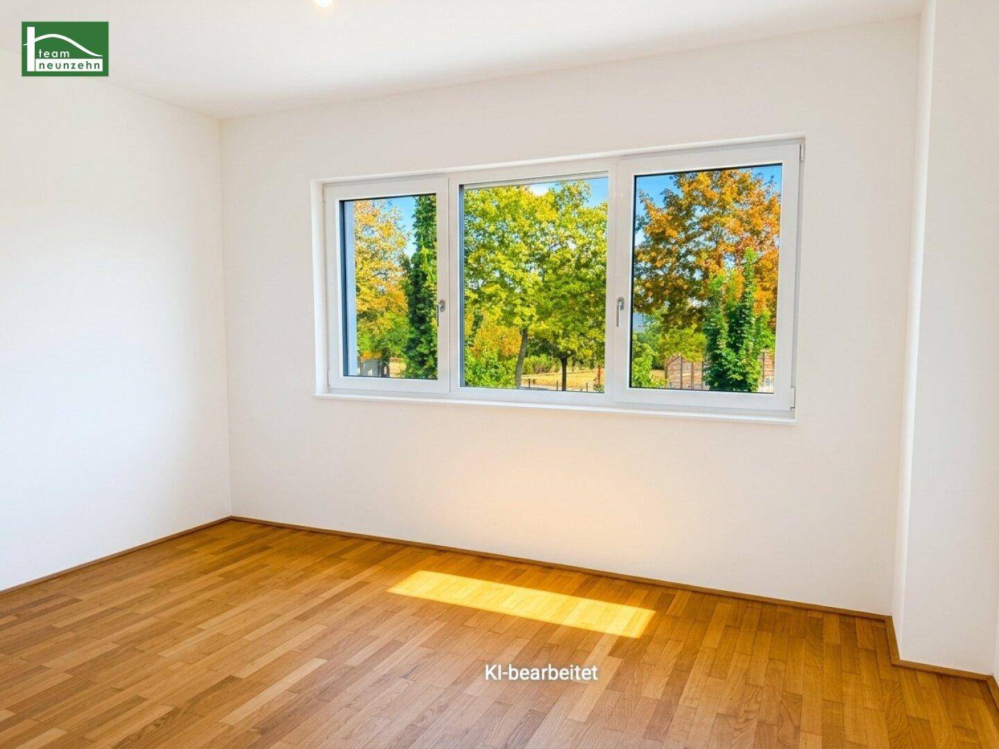 Helles Schlafzimmer mit Parkettboden und großem Fenster, das einen schönen Blick ins Grüne bietet.