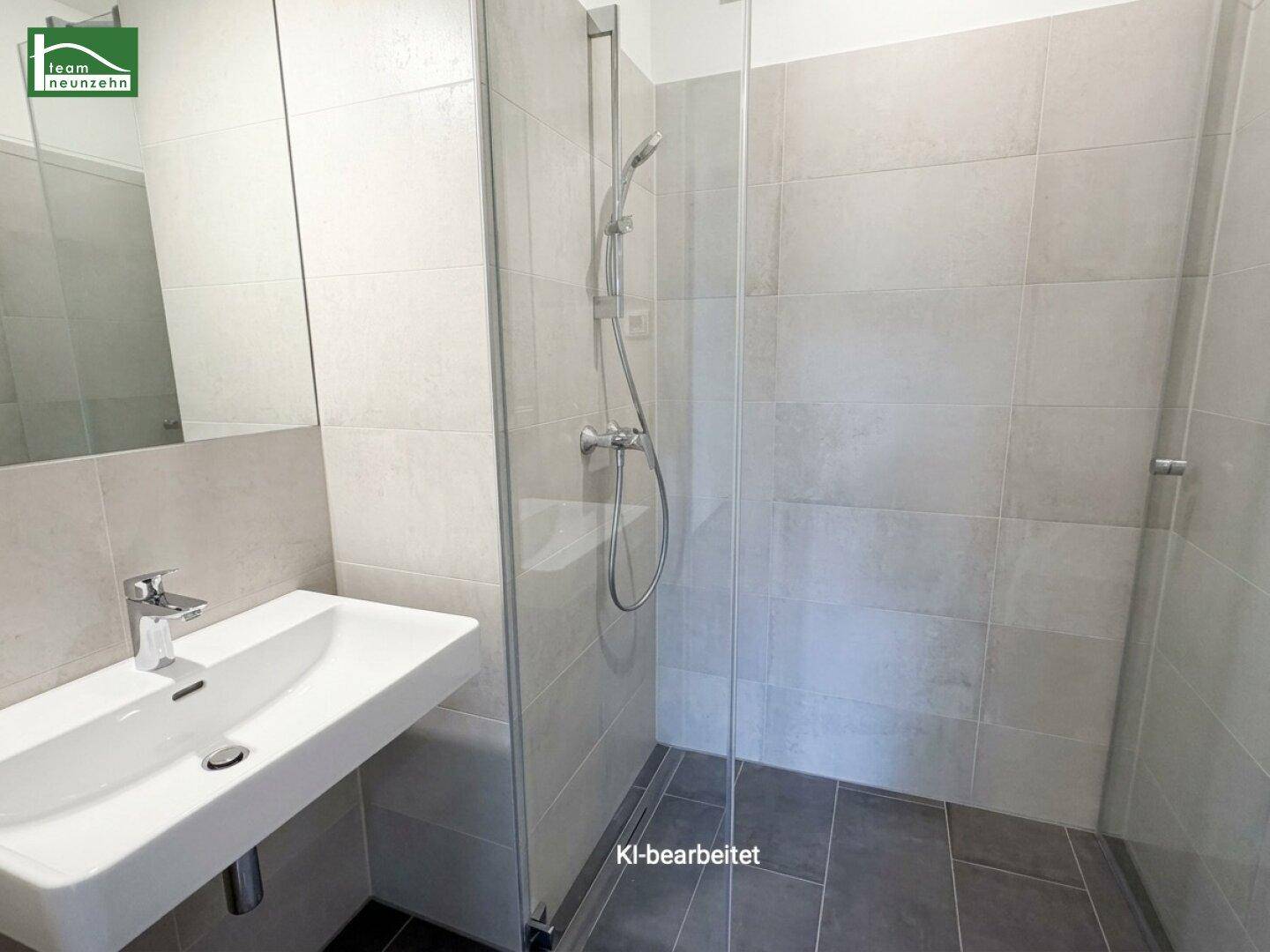 Modernes Badezimmer mit begehbarer Dusche, Einzelwaschbecken und großem Spiegel, hell gefliest.