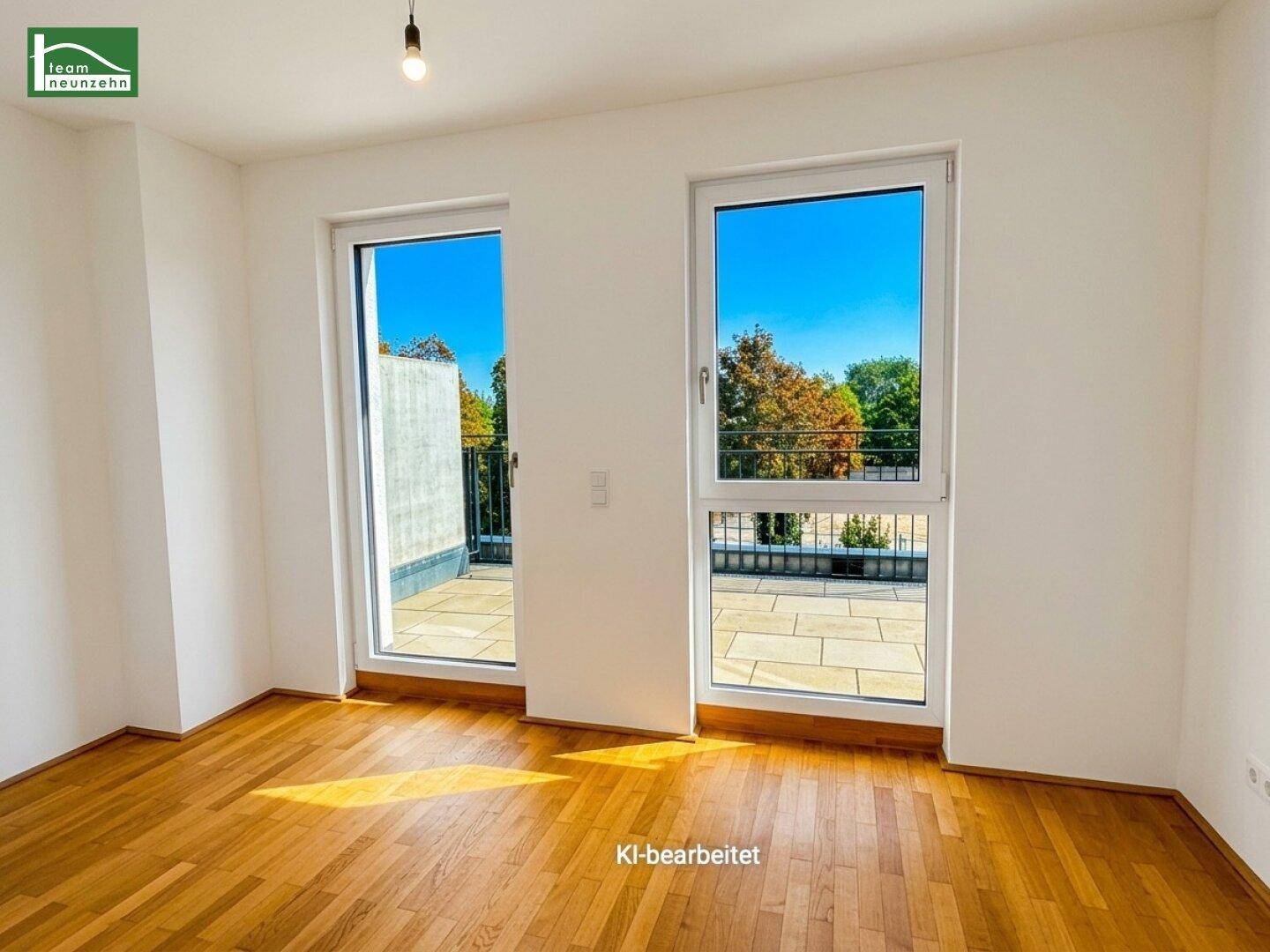 Helles Zimmer mit Holzboden und Zugang zu einer gefliesten Terrasse, durchflutet von Sonnenlicht.