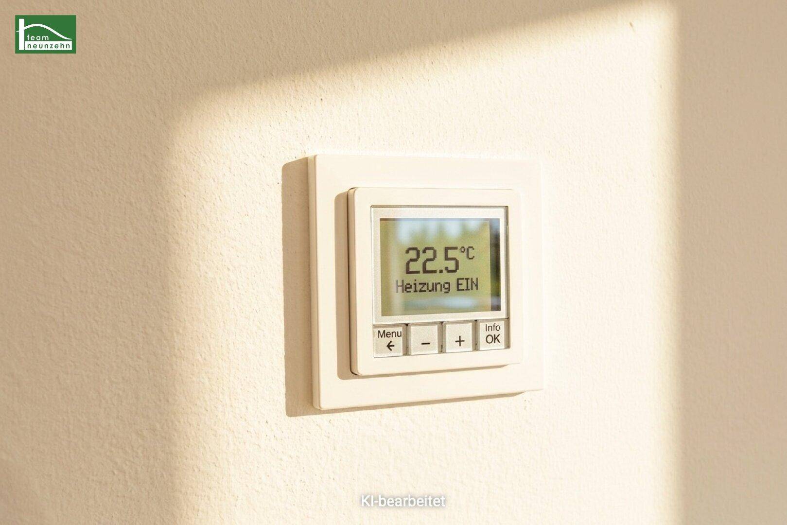 Digitaler Thermostat zur Steuerung der Heizung, an einer hellen Wand montiert.
