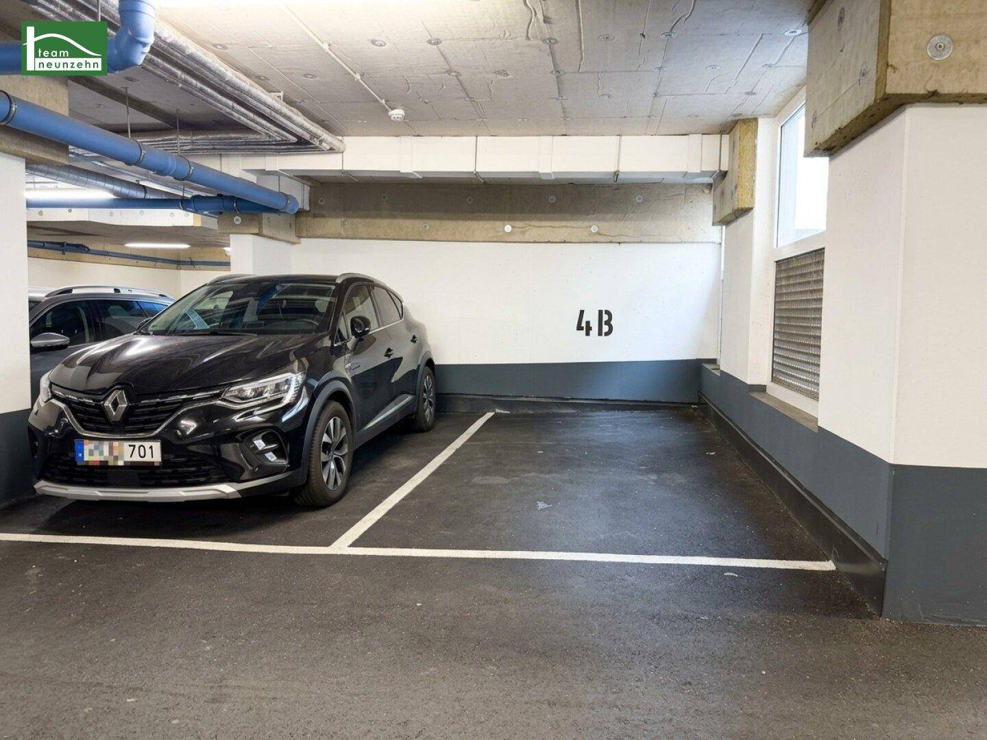 Tiefgaragenstellplatz 4B mit einem geparkten schwarzen SUV und weißer Markierung.