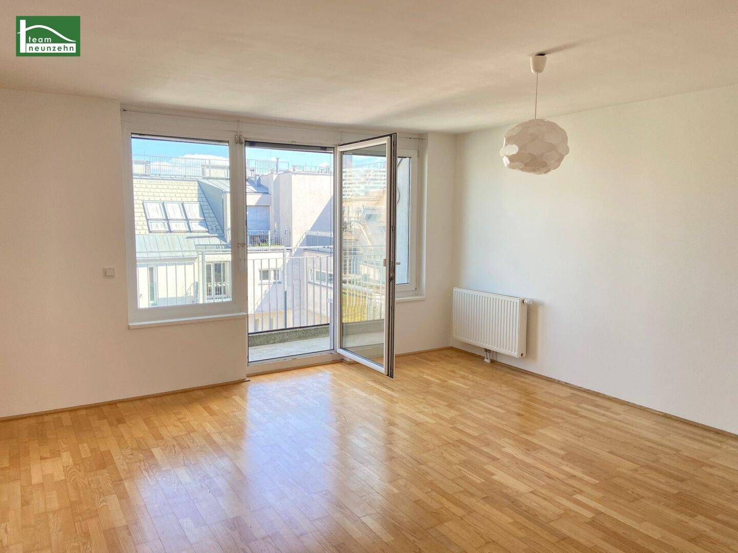 Geräumiges Zimmer mit hellem Parkettboden und weitem Blick durch die großen Fenster.